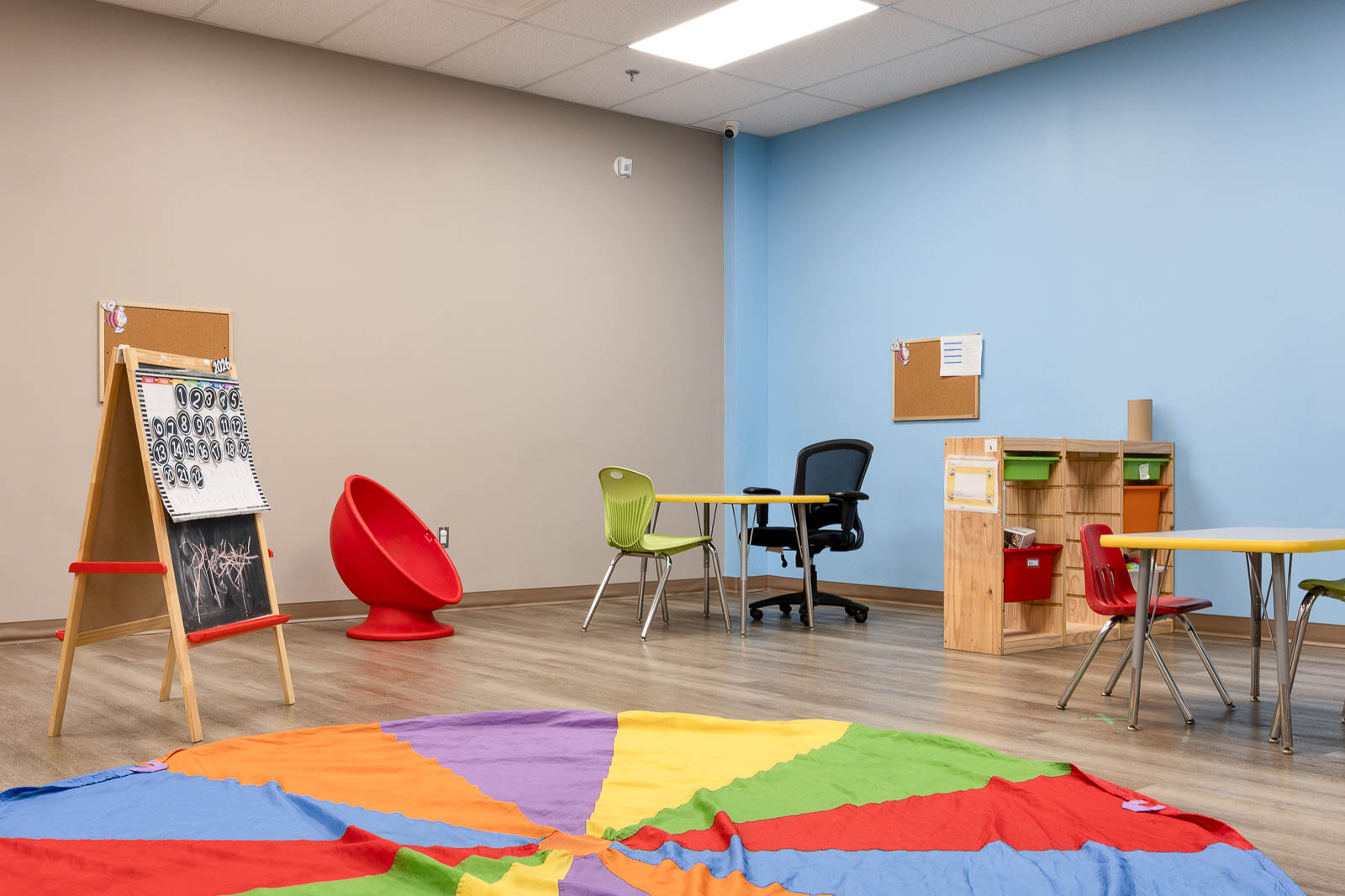 Easel, egg chair and child-size table in an early-years room at AlphaBee Etobicoke